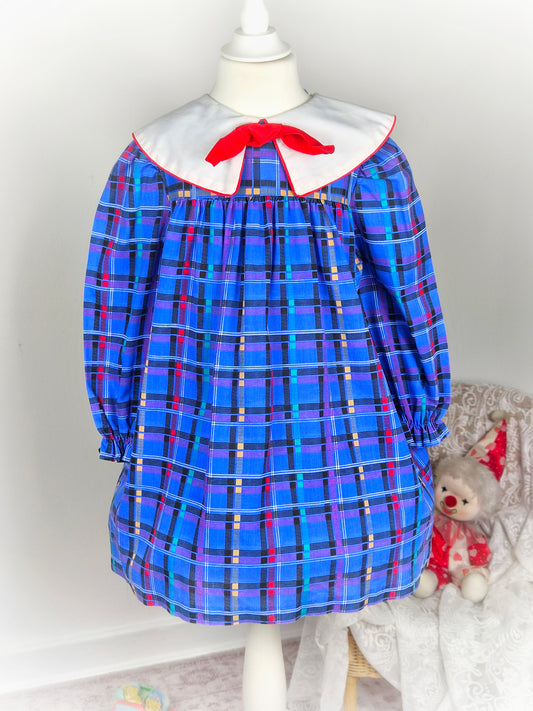 5 years. Blue checkered vintage dress with bright patterns, white collar and red bow. Little Evie
