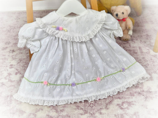 3-6 months. White vintage eyelet dress with frilly hem and dainty rosettes