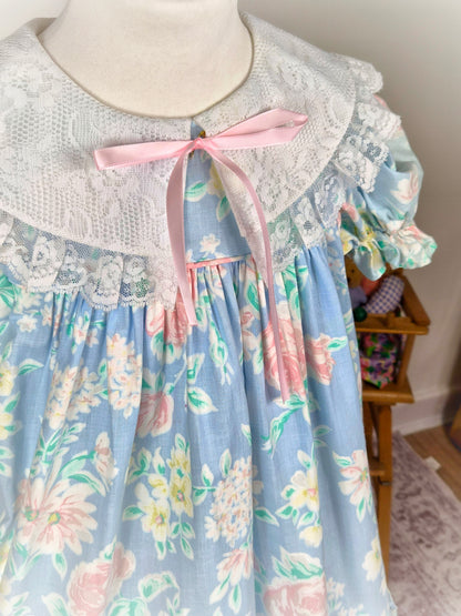 5 years. Blue floral vintage Bryan dress with white lace bib and hem and pink ribbon. Small faults*