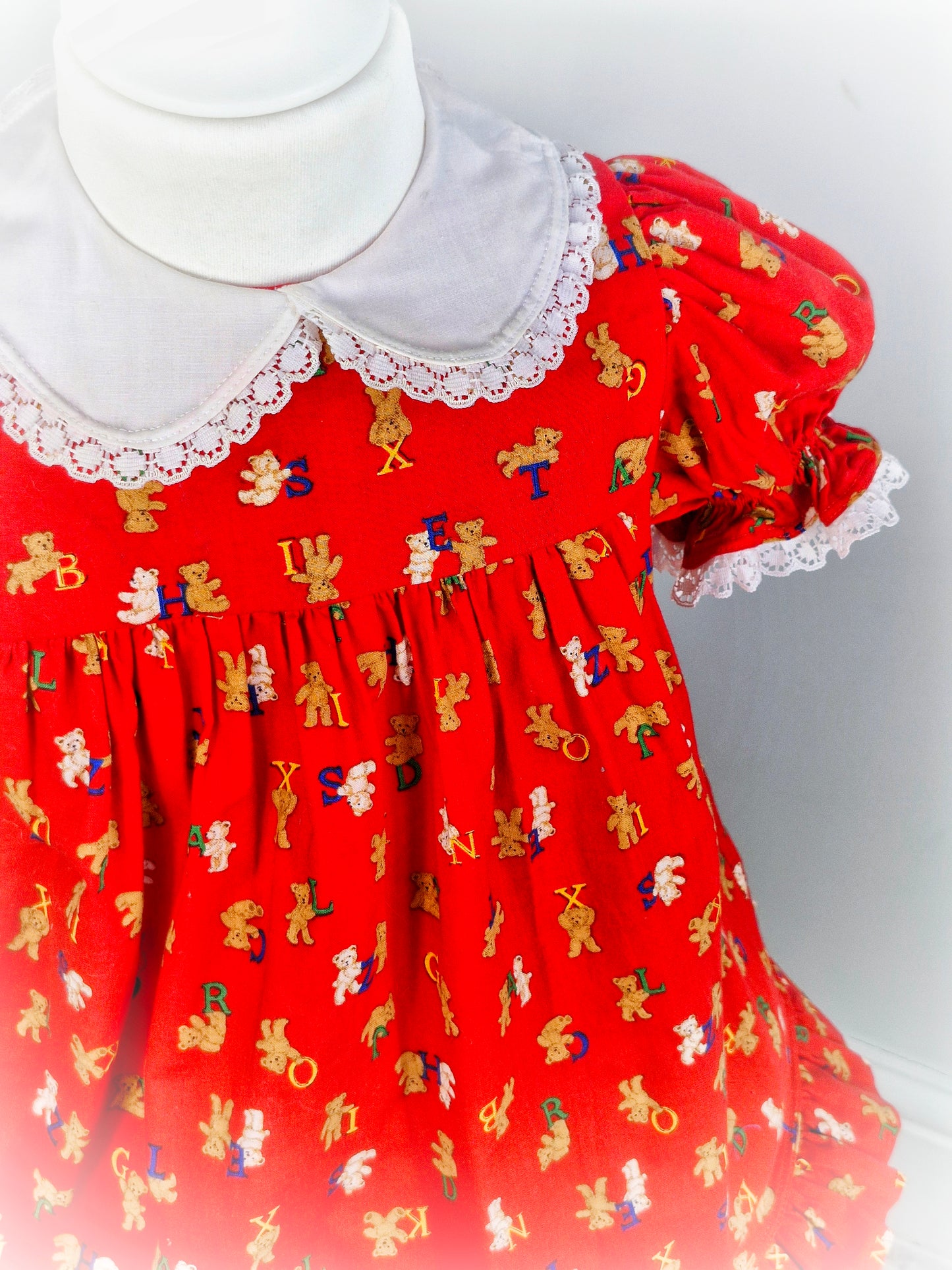 2-3 years. Red dress with cute teddy print, white collar and puff sleeves.