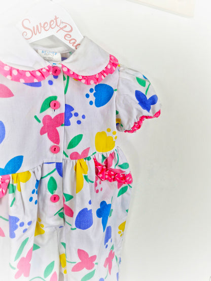18 months. White romper with bright flowers and butterflies and polka dot trim. From Cuties by Judy