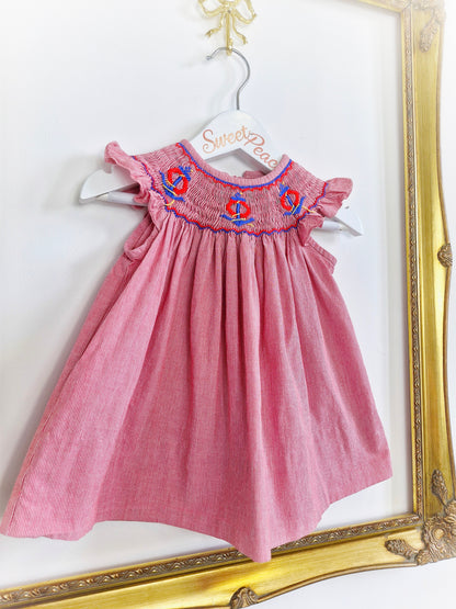 9-12 months. Vintage inspired, red and white striped dress with flutter sleeves, smocking and embroidered anchors