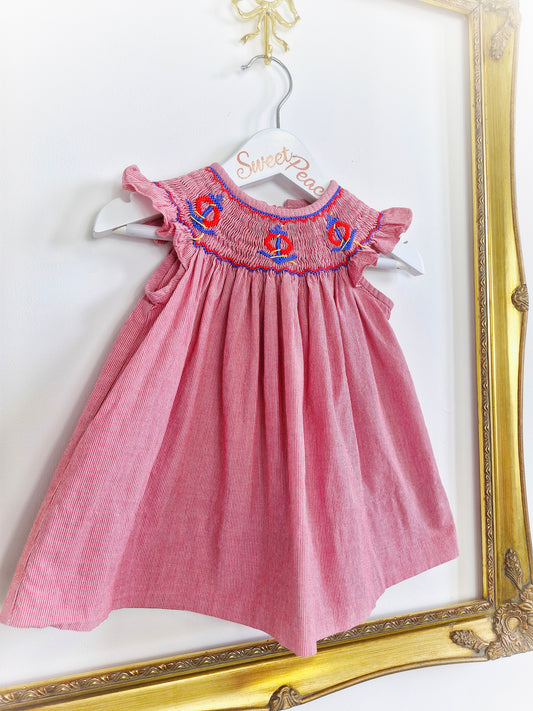9-12 months. Vintage inspired, red and white striped dress with flutter sleeves, smocking and embroidered anchors