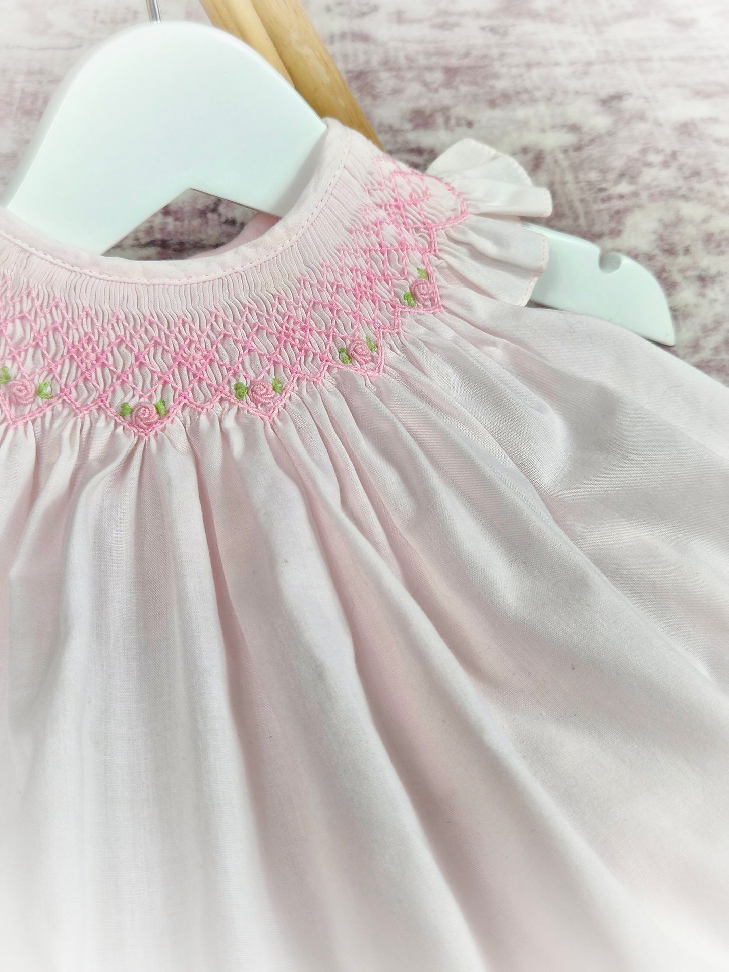 6 months. Vintage inspired pink smock dress with flutter sleeves and pink embroidery