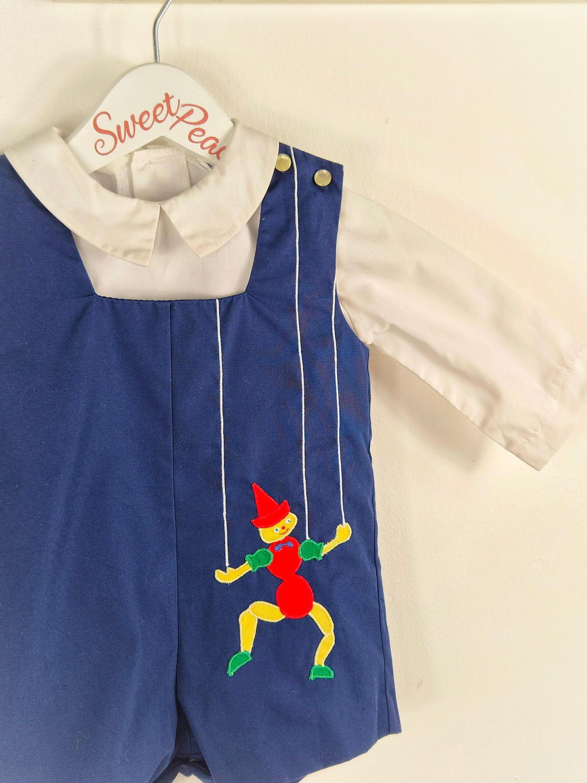 12 months. Two-piece vintage Nannette set, navy short dungarees with white shirt and puppet applique