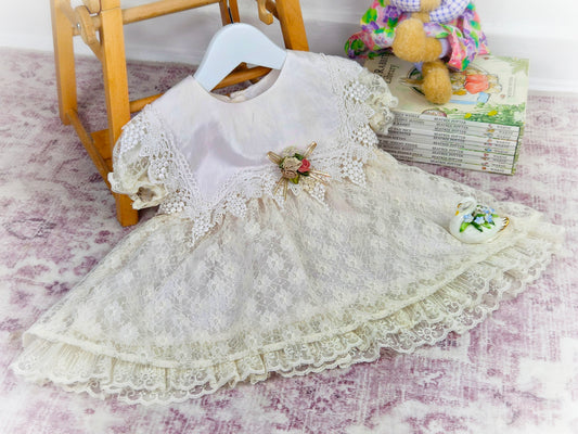 12-18 months. Cream lace vintage dress with beautiful bib trim and floral centre