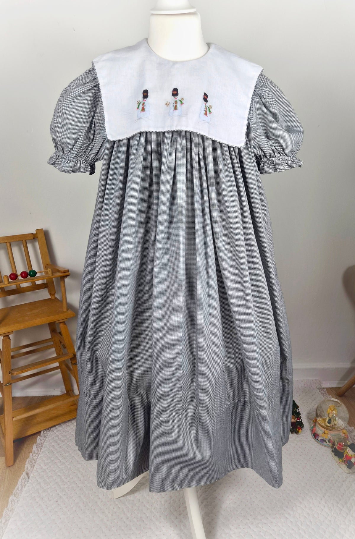 10 years. Black and white gingham, vintage handmade dress by Amanda Kertzembend with large white bib embroidered with snowmen