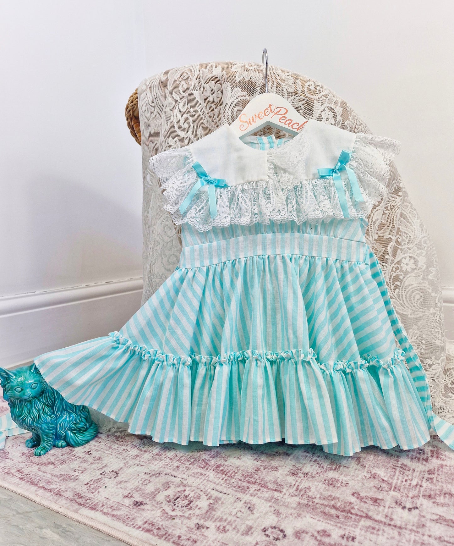 2 years. Mint and white sleeveless, striped dress with white bib, lace and bows
