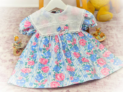 18-24 months. Vintage Kalula Kids dress with blue and pink floral design, large white bib with bow & lace details