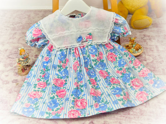18-24 months. Vintage Kalula Kids dress with blue and pink floral design, large white bib with bow & lace details