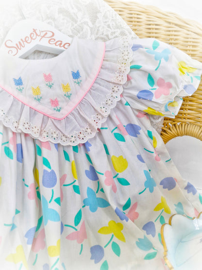 9-12 months. White dress with pastel flowers and butterflies and embroidered bib