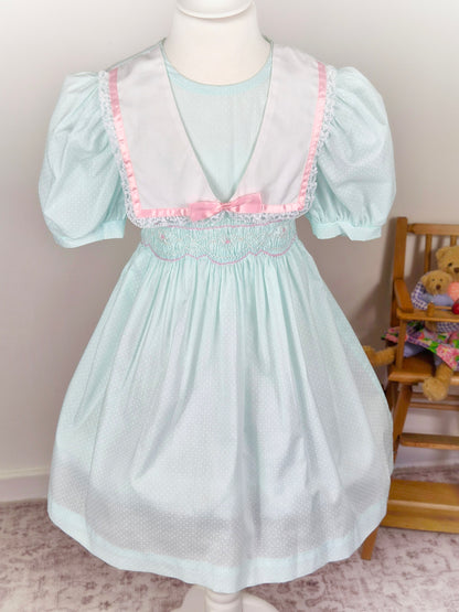 5 years. Mint vintage Polly Flinders smocked dress eith puff sleeves, white collar and pink satin ribbon