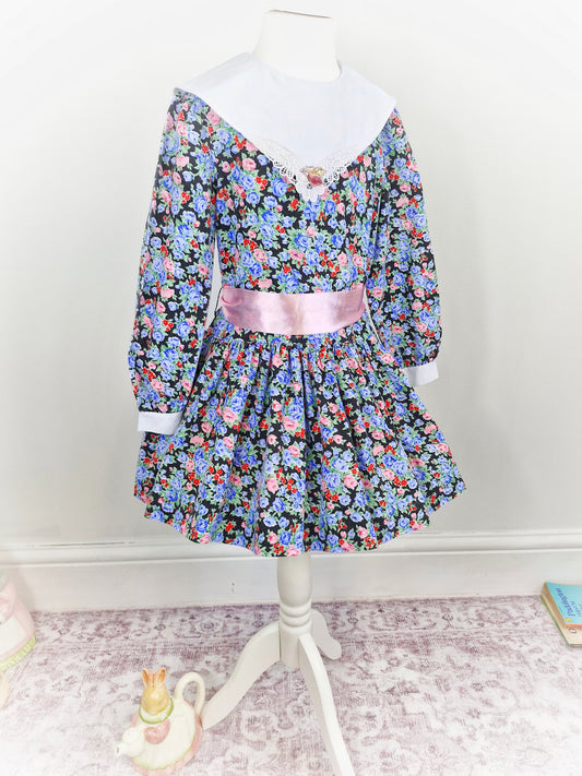 5 years. Black floral dress with white bib